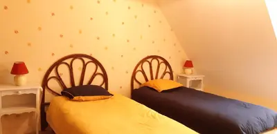 Un ou plusieurs lits dans un hébergement de l'établissement Gite de Kervao, Camélias, proche mer (800 mètres), meublé tourisme 3 étoiles