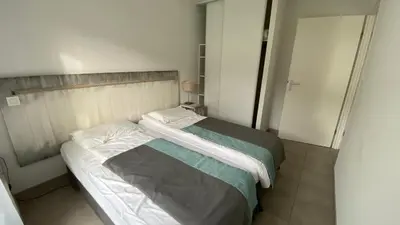 Un ou plusieurs lits dans un hébergement de l'établissement T2 avec piscine en résidence 4 étoiles