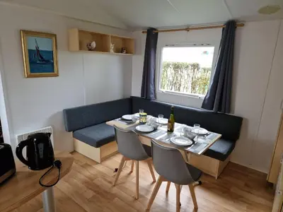 Coin salon dans l'établissement Mobil Home Beg Meil 300m plage avec piscine partagée, terrasse privée et Wi-Fi