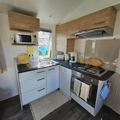 Cuisine ou kitchenette dans l'établissement Mobil-home 2 ch - 4-6 pers - Terrasse & WiFi - Domaine de Kerlann