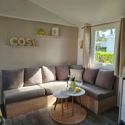 Coin salon dans l'établissement Mobil-home 2 ch - 4-6 pers - Terrasse & WiFi - Domaine de Kerlann
