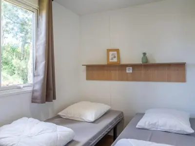 Un ou plusieurs lits dans un hébergement de l'établissement Mobil home confortable avec terrasse à Tréguennec - API-1-52-1036