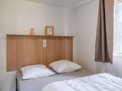 Un ou plusieurs lits dans un hébergement de l'établissement Mobil home confortable avec terrasse à Tréguennec - API-1-52-1036