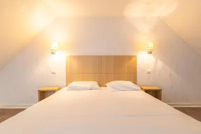 Un ou plusieurs lits dans un hébergement de l'établissement Manoir de Moëllien, The Originals Relais