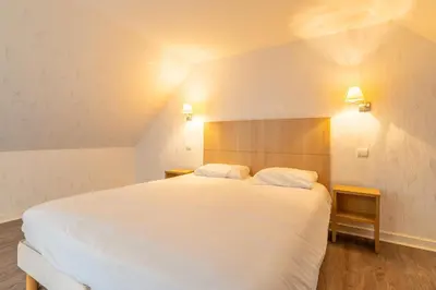 Un ou plusieurs lits dans un hébergement de l'établissement Manoir de Moëllien, The Originals Relais