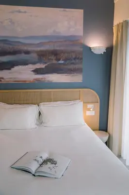 Un ou plusieurs lits dans un hébergement de l'établissement Hôtel Les Grands Voyageurs