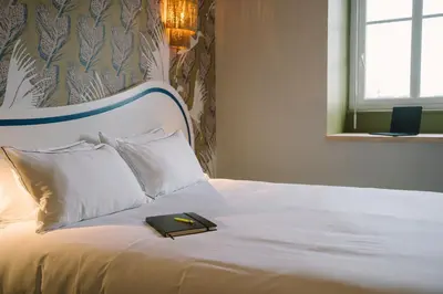 Un ou plusieurs lits dans un hébergement de l'établissement Hôtel Les Grands Voyageurs