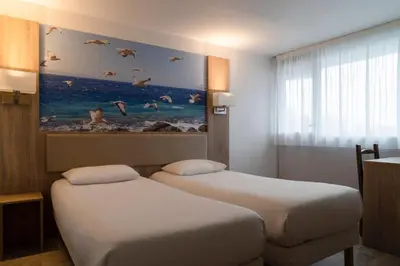 Un ou plusieurs lits dans un hébergement de l'établissement BRIT HOTEL Confort MORLAIX