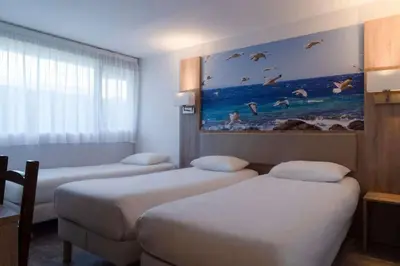 Un ou plusieurs lits dans un hébergement de l'établissement BRIT HOTEL Confort MORLAIX