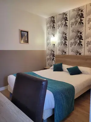 Un ou plusieurs lits dans un hébergement de l'établissement Brit Hotel des Halles