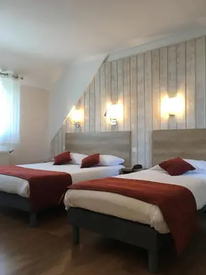Un ou plusieurs lits dans un hébergement de l'établissement Brit Hotel des Halles
