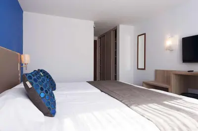 Un ou plusieurs lits dans un hébergement de l'établissement Brit Hôtel De L'océan