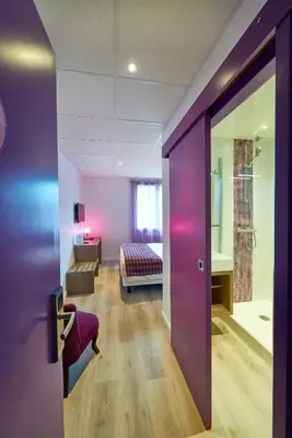 Un ou plusieurs lits dans un hébergement de l'établissement Cozy hôtel logis Morlaix