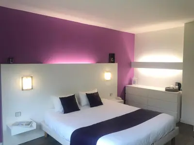 Un ou plusieurs lits dans un hébergement de l'établissement Logis Latitude Ouest Hôtel Restaurant & Spa