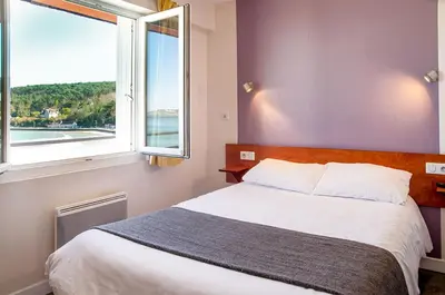 Un ou plusieurs lits dans un hébergement de l'établissement Hôtel & Restaurant de la Plage