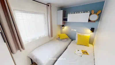 Un ou plusieurs lits dans un hébergement de l'établissement Camping Officiel Siblu Domaine de Kerlann
