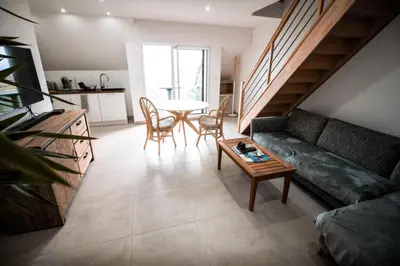 Coin salon dans l'établissement APPART-DUPLEX VUE MER PANORAMIQUE BALCON & PISCINE proche commerce