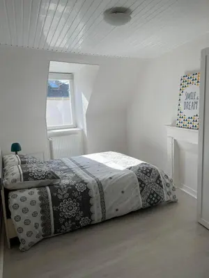 Un ou plusieurs lits dans un hébergement de l'établissement Charmante maison de ville avec parking à côté.